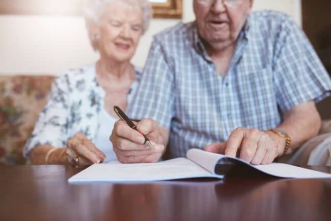 elderly-couple-signing-important-document
