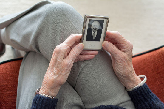 senior-lady-looking-at-image-of-deceased-loved-one