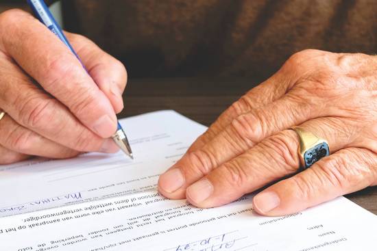 elderly-man-signing-document