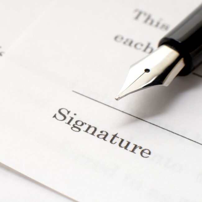 Celebrities Who Chose Not to Leave Their Children an Inheritance Person signing a will with legal papers and family photos representing celebrity inheritance decisions.